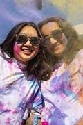 Smiling brandeis students covered in paint during the Indian celebration of Holi